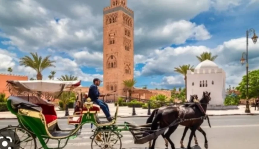 2 Days Tour From Marrakech To Zagora 20 A vibrant sunset casting golden hues over the windswept sand dunes in Merzouga, with silhouettes of visitors riding camels, embarking on a 2 days tour From Marrakech to zagora desert tour
