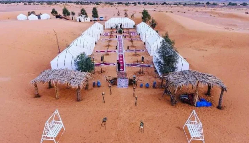 What to do in Morocco in May 2 What to do in Morocco in May . Peaceful sunset over the sweeping sands of the Zagora Desert with a luxurious tourist resort nestled in tranquility, offering a serene and romantic getaway.